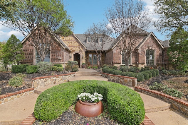 tudor home with brick siding and stone siding