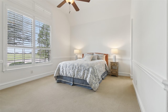 carpeted bedroom featuring multiple windows, ceiling fan, vaulted ceiling, and baseboards
