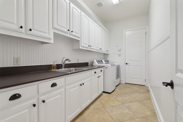 laundry area featuring cabinet space, a sink, baseboards, visible vents, and washer and clothes dryer