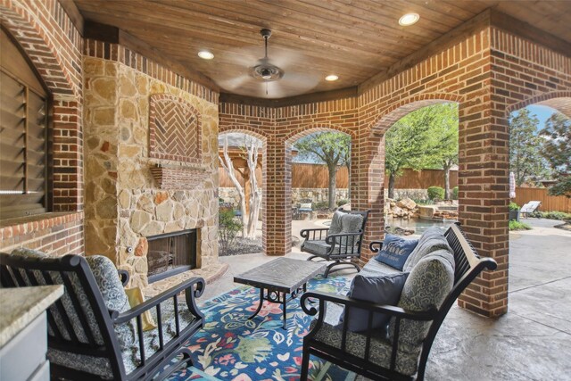 view of patio with fence and an outdoor living space with a fireplace