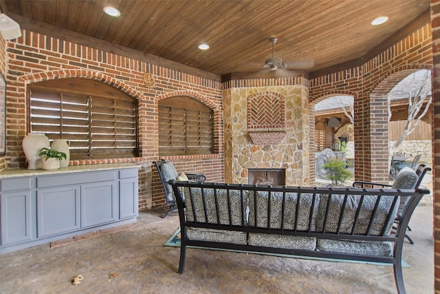 view of patio / terrace with an outdoor stone fireplace and ceiling fan