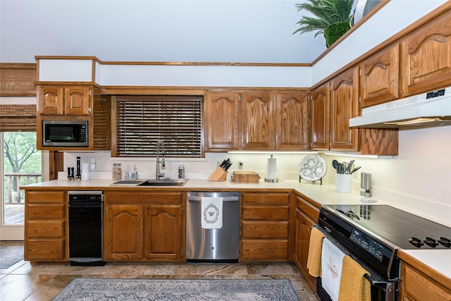 kitchen featuring stainless steel appliances, a sink, brown cabinetry, light countertops, and under cabinet range hood