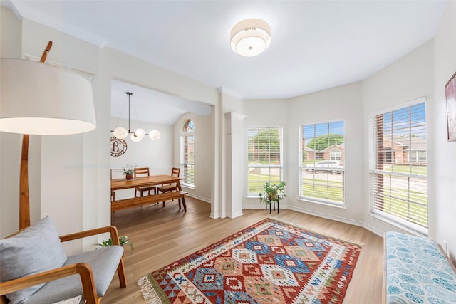living area featuring baseboards, a chandelier, and light wood-style floors