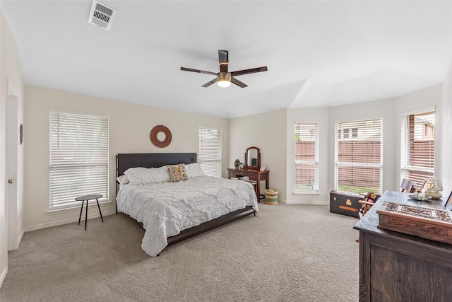 bedroom with visible vents, a ceiling fan, baseboards, and light carpet