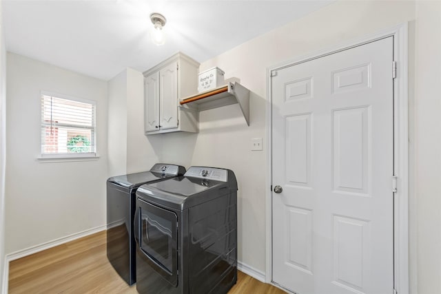 laundry area featuring light wood finished floors, baseboards, independent washer and dryer, and cabinet space