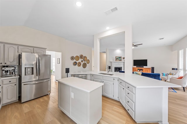 kitchen featuring a sink, open floor plan, light countertops, appliances with stainless steel finishes, and visible vents