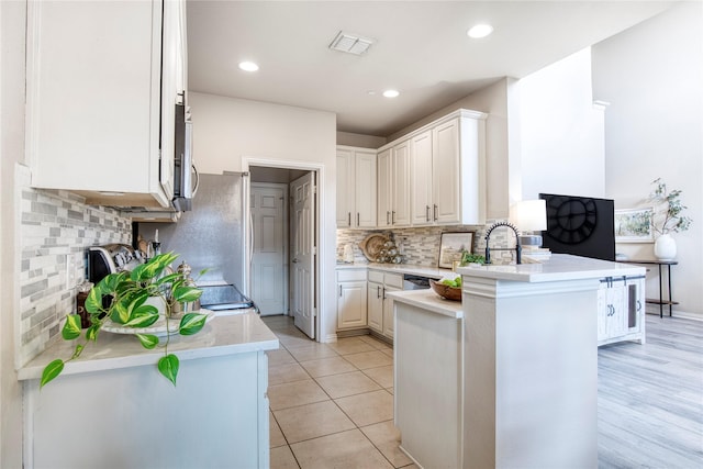 8741 Bigelow Dr, Plano, TX 75024 - kitchen featuring a peninsula, light countertops, decorative backsplash, white cabinetry, and recessed lighting