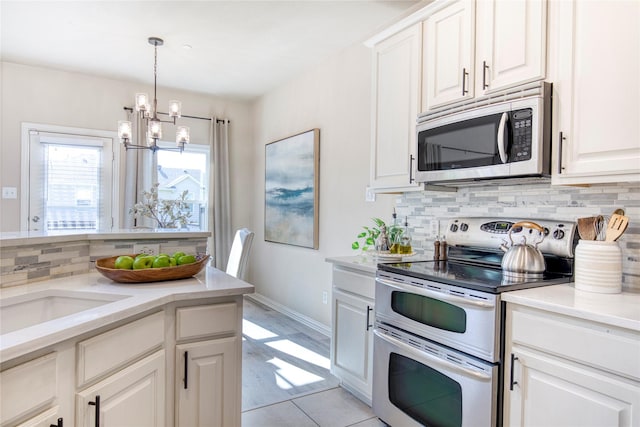 8741 Bigelow Dr, Plano, TX 75024 - kitchen featuring appliances with stainless steel finishes, a chandelier, tasteful backsplash, light countertops, and white cabinets