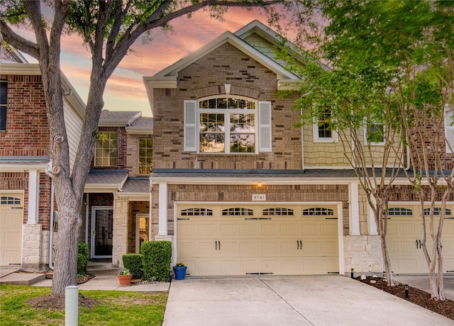 8741 Bigelow Dr, Plano, TX 75024 - view of front of property featuring an attached garage, driveway, stone siding, and brick siding