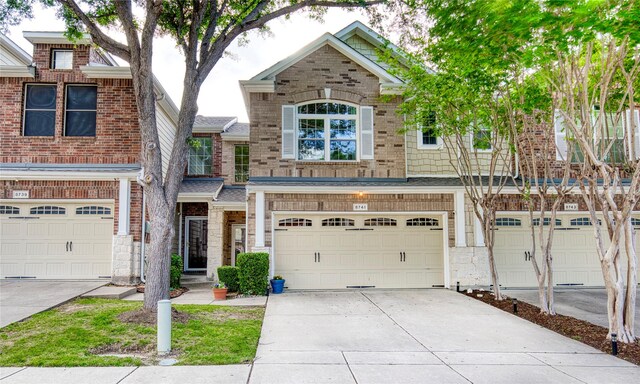 8741 Bigelow Dr, Plano, TX 75024 - townhome / multi-family property with concrete driveway, an attached garage, stone siding, and brick siding