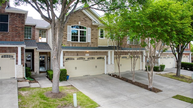 8741 Bigelow Dr, Plano, TX 75024 - townhome / multi-family property featuring driveway, an attached garage, brick siding, and a shingled roof