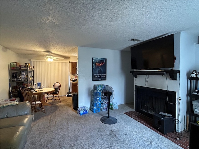 612 Ridgeline Dr, Hurst, TX 76053 - carpeted living area featuring a textured ceiling, ceiling fan, and a tiled fireplace