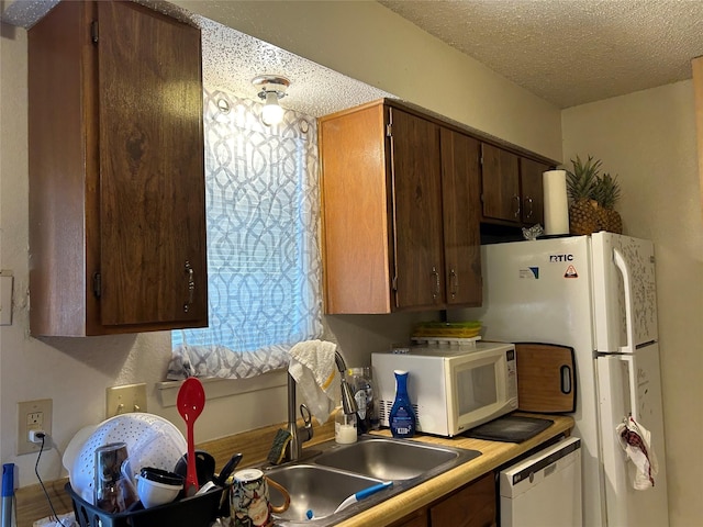 612 Ridgeline Dr, Hurst, TX 76053 - kitchen with white appliances, a textured ceiling, a sink, and light countertops