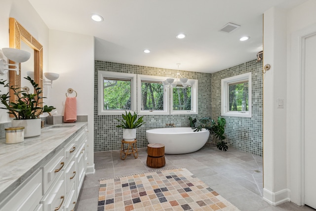 full bathroom with recessed lighting, tile walls, a soaking tub, and vanity