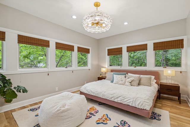 bedroom featuring light wood-type flooring, baseboards, an inviting chandelier, and recessed lighting