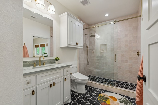 full bath featuring vanity, visible vents, a shower stall, and toilet
