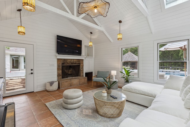 tiled living area with beamed ceiling, a stone fireplace, and wood walls