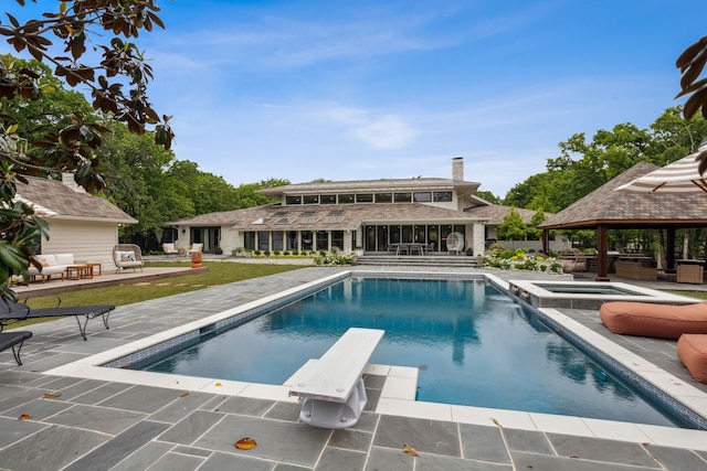 outdoor pool featuring a gazebo, a diving board, a yard, a patio, and an in ground hot tub