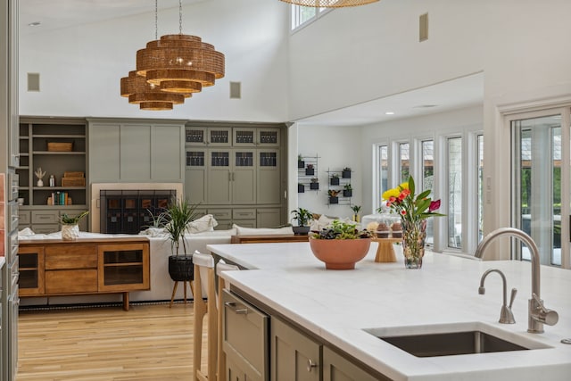 kitchen with a towering ceiling, open floor plan, a sink, and plenty of natural light