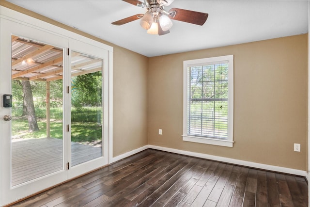 unfurnished room featuring baseboards, a ceiling fan, and dark wood-type flooring