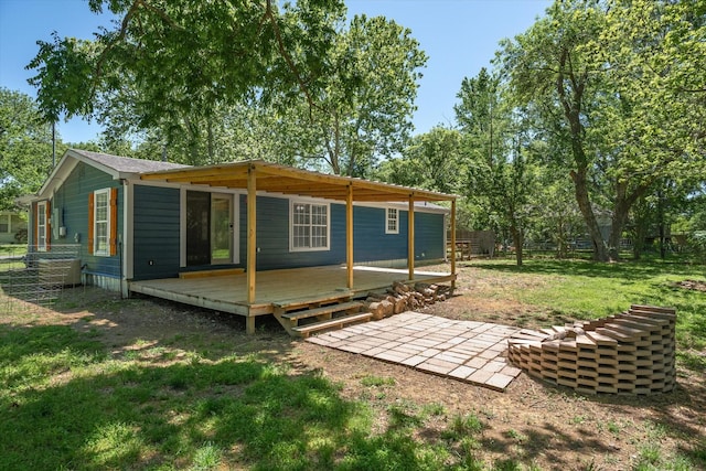 back of house with fence, a lawn, and a deck