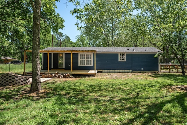 back of house with fence, a yard, and a deck
