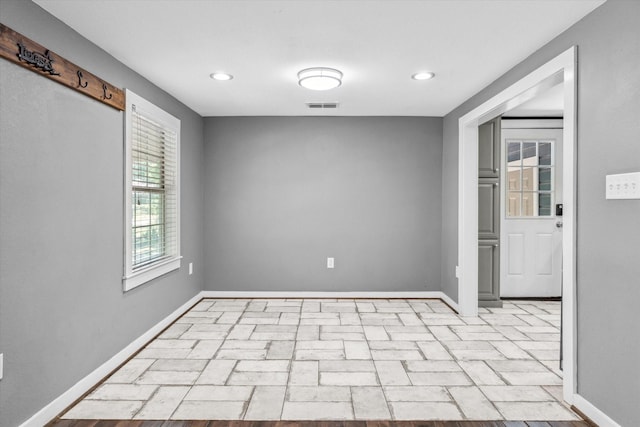 spare room with baseboards, visible vents, and recessed lighting