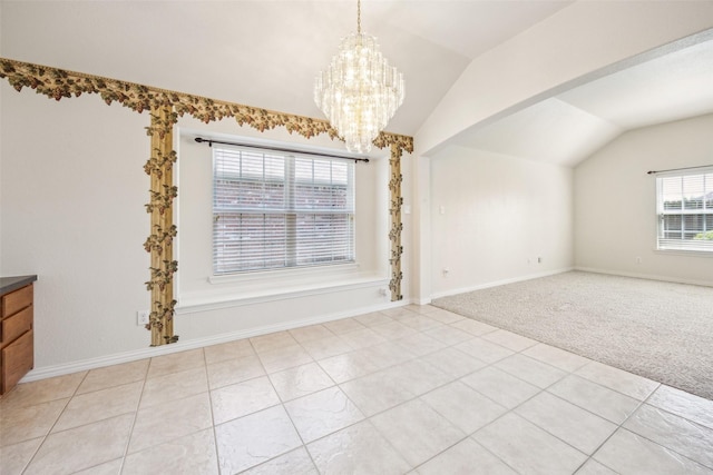 unfurnished dining area featuring baseboards, lofted ceiling, a notable chandelier, and light carpet