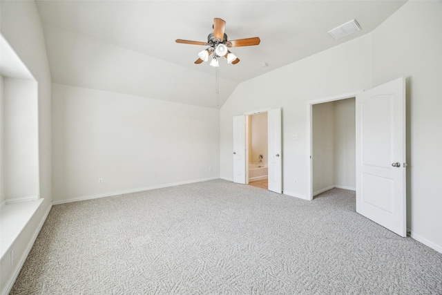 unfurnished bedroom featuring vaulted ceiling, carpet floors, visible vents, and baseboards