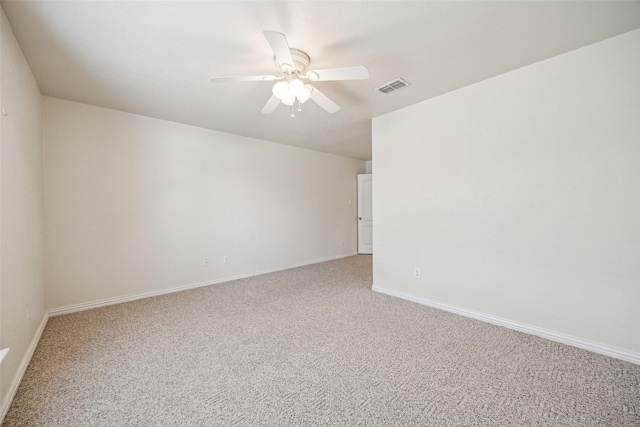 unfurnished room with light colored carpet, baseboards, a ceiling fan, and visible vents