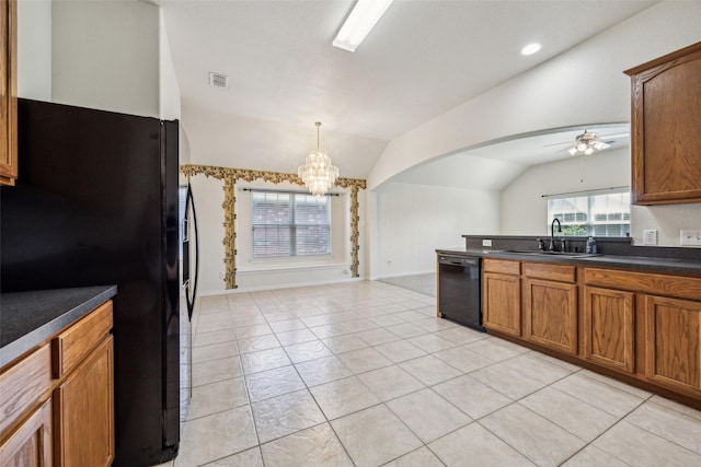 kitchen with vaulted ceiling, visible vents, a sink, black appliances, and ceiling fan with notable chandelier
