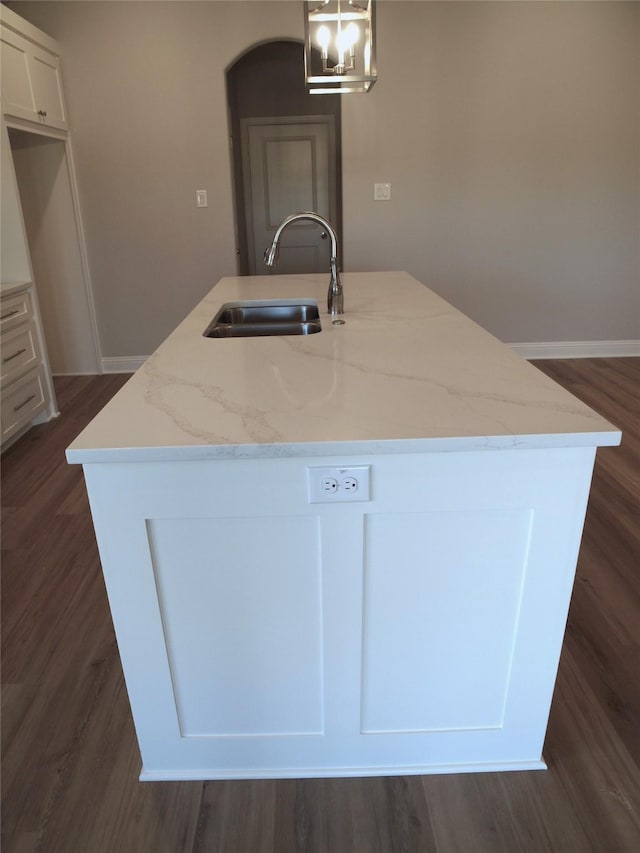 725 Raylan St, Springtown, TX 76082 - kitchen with a sink, a kitchen island with sink, decorative light fixtures, white cabinetry, and light stone countertops