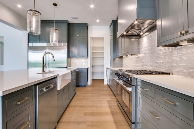 2016 Meadowlark, Aledo, TX 76008 - kitchen featuring wall chimney exhaust hood, light countertops, premium appliances, and tasteful backsplash