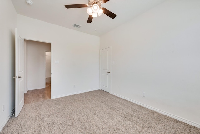 empty room with light carpet, a ceiling fan, visible vents, and baseboards