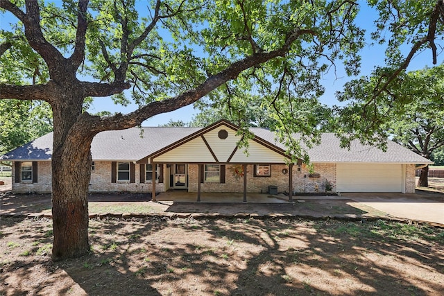 single story home featuring concrete driveway, an attached garage, brick siding, and covered porch