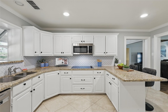kitchen featuring a sink, a breakfast bar, stainless steel appliances, a peninsula, and ornamental molding