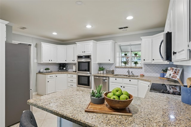 kitchen with visible vents, appliances with stainless steel finishes, decorative backsplash, and a sink