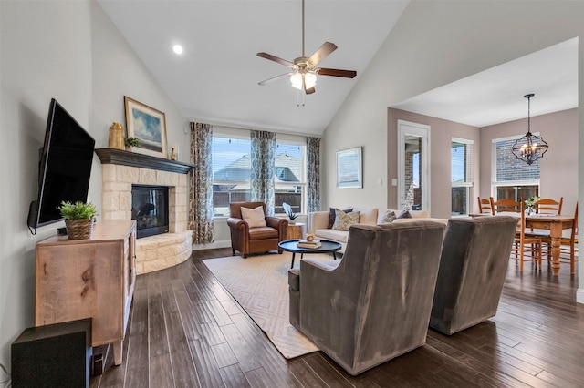 living area with recessed lighting, high vaulted ceiling, ceiling fan with notable chandelier, a fireplace, and dark wood-type flooring