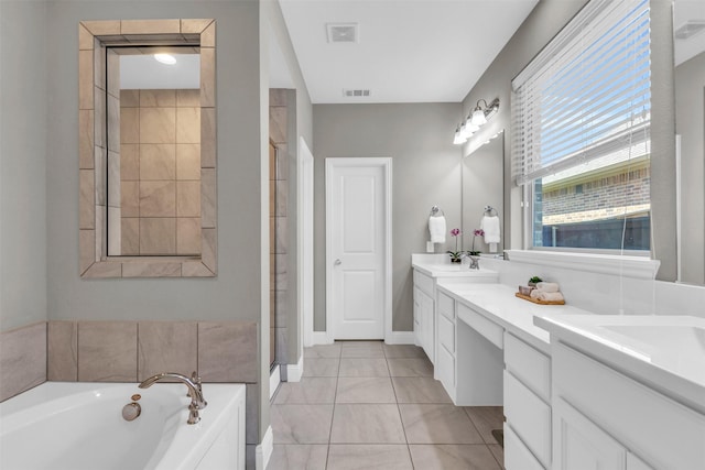 bathroom with a bath, visible vents, a sink, and double vanity