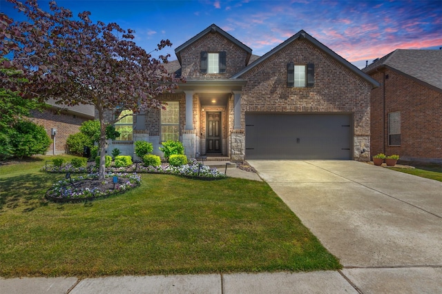 traditional-style home featuring brick siding, a yard, driveway, and a garage