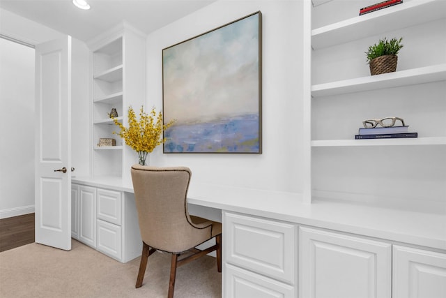 office featuring recessed lighting, built in study area, built in shelves, and light carpet