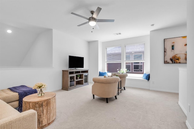 carpeted living room featuring ceiling fan and baseboards