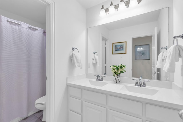 full bath featuring toilet, tile patterned floors, a sink, and double vanity