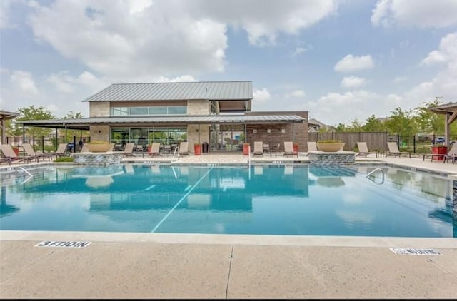 community pool featuring fence and a patio area