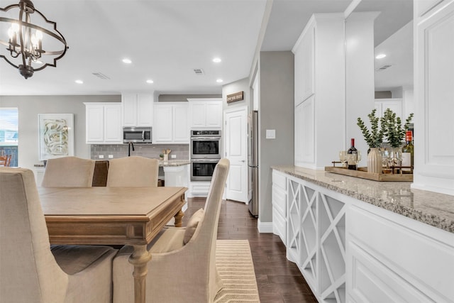 interior space with an inviting chandelier, visible vents, recessed lighting, and dark wood-style flooring