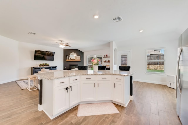 11225 Klondike Ln, Aubrey, TX 76227 - kitchen with visible vents, ceiling fan, open floor plan, a kitchen island, and light wood-style floors