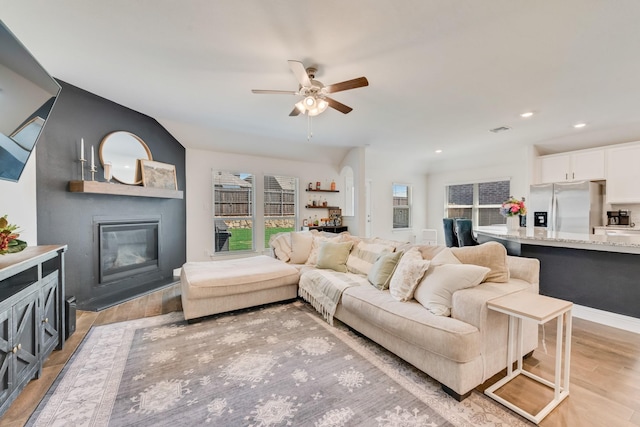 11225 Klondike Ln, Aubrey, TX 76227 - living area with light wood finished floors, a healthy amount of sunlight, a fireplace, and ceiling fan