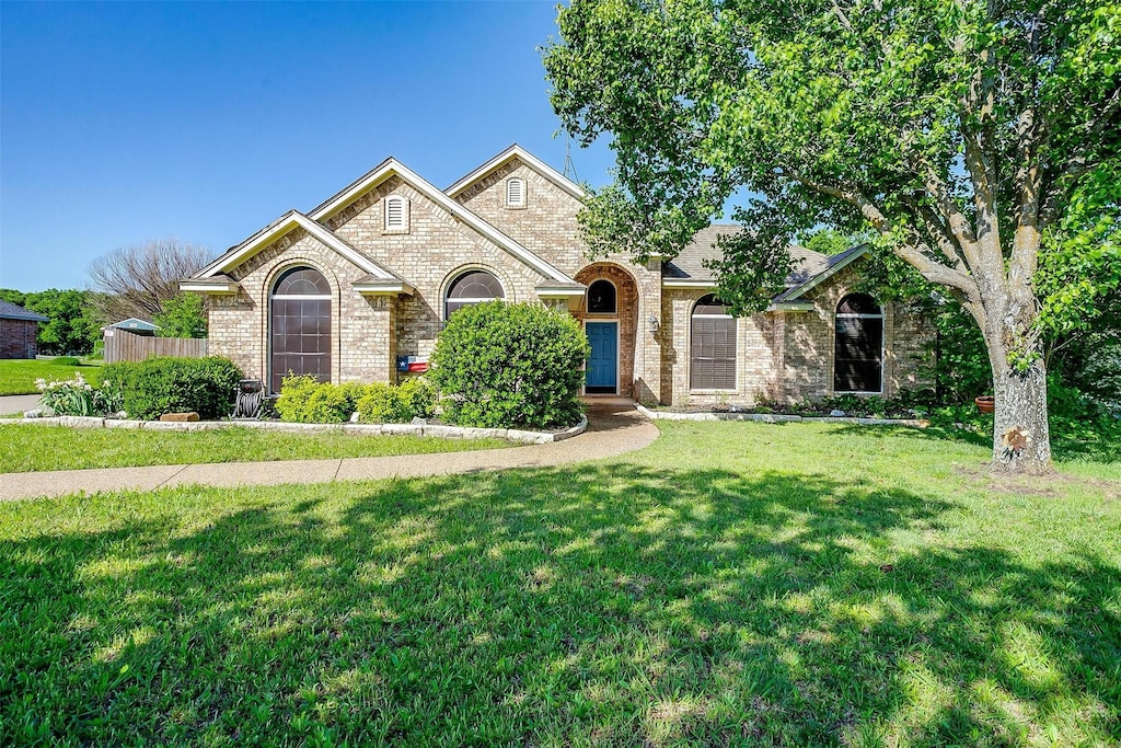 view of front of property featuring a front lawn and brick siding