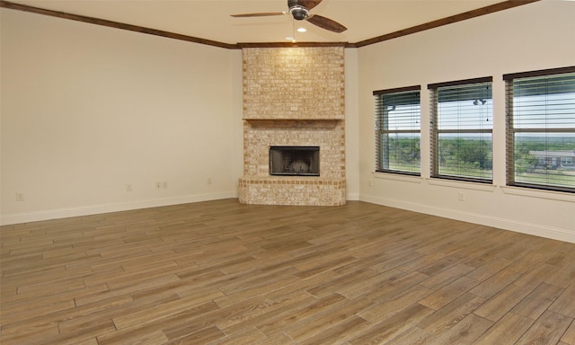 217 Timber Valley Ct, Weatherford, TX 76085 - unfurnished living room featuring a ceiling fan, wood finished floors, crown molding, baseboards, and a brick fireplace