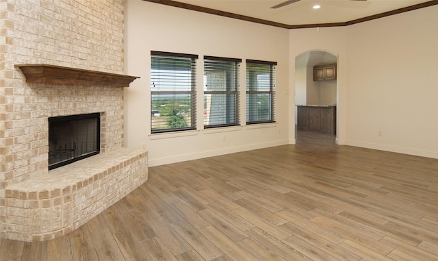 217 Timber Valley Ct, Weatherford, TX 76085 - unfurnished living room with a ceiling fan, arched walkways, wood finished floors, baseboards, and crown molding
